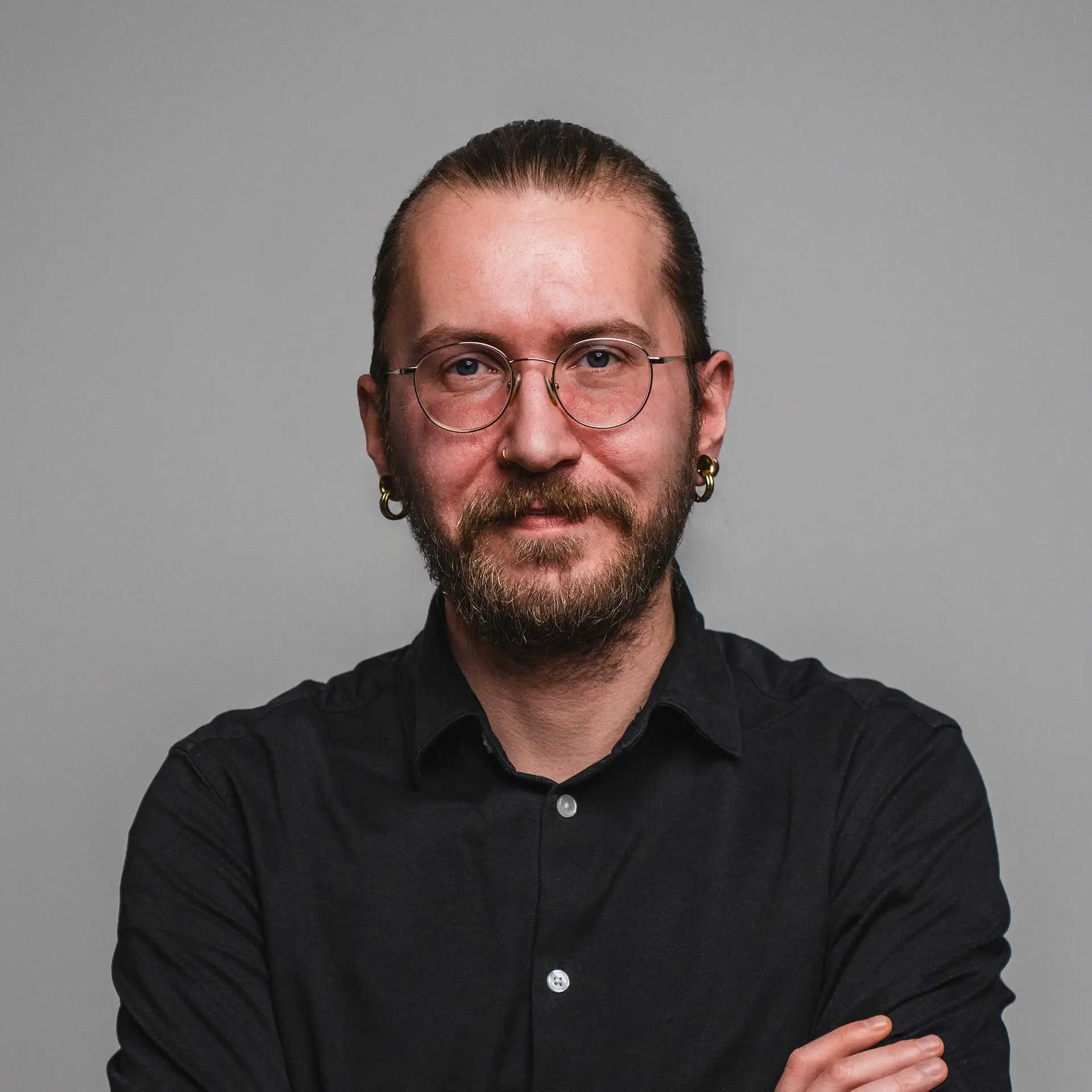 Person mit Brille und Bart trägt schwarzes Hemd